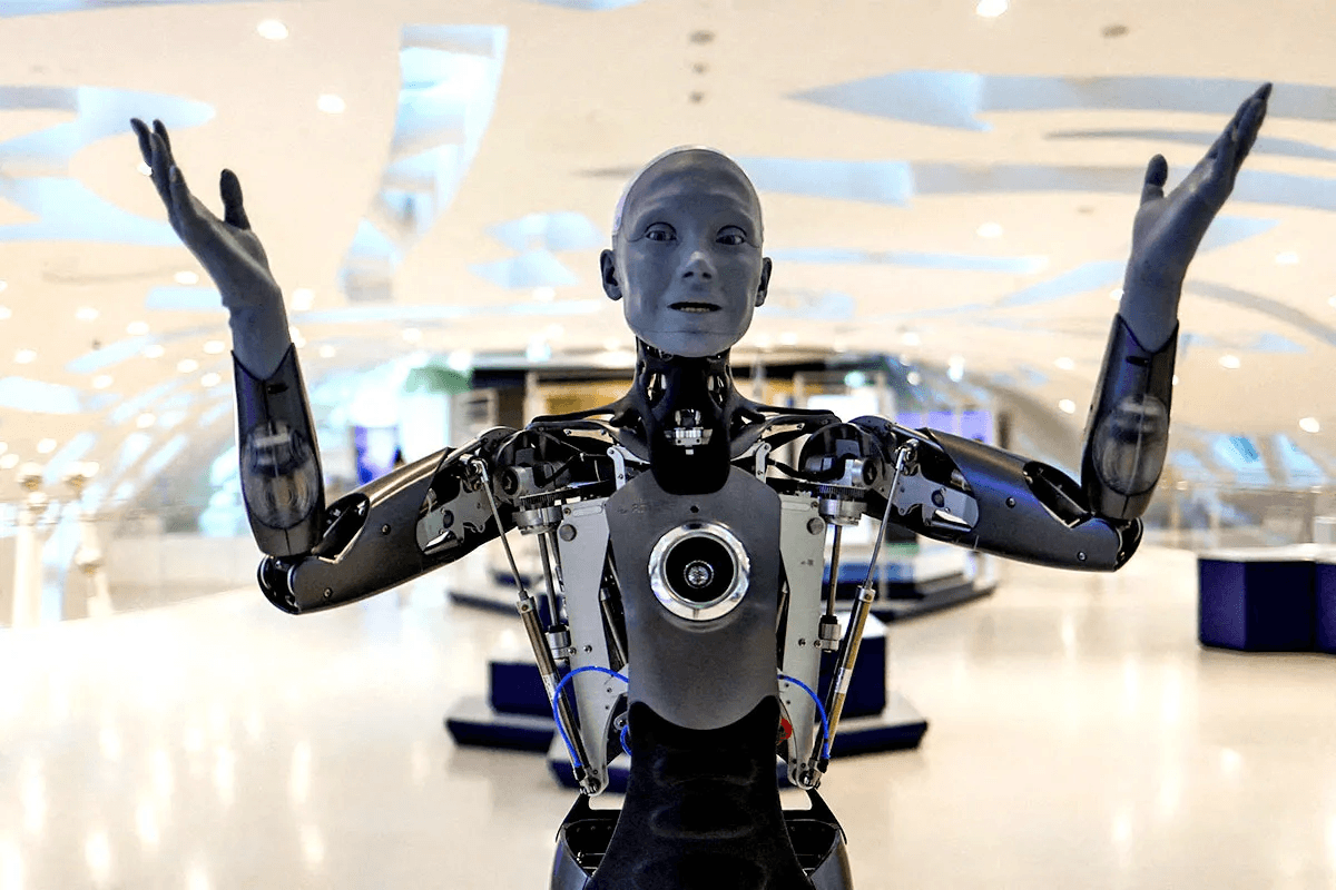A humanoid robot named Ameca smiles and interacts with a group of museum visitors at the Museum of the Future in Dubai.